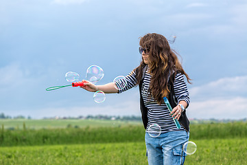 Image showing Beautiful Young Woman make Blowing Bubbles