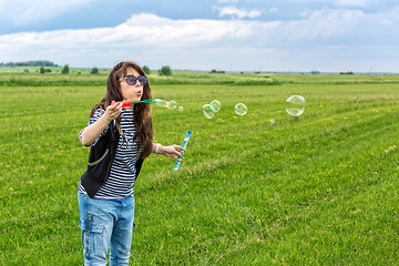 Image showing Beautiful Young Woman make Blowing Bubbles