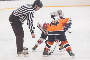 Image showing Puck playing between players of ice-hockey teams