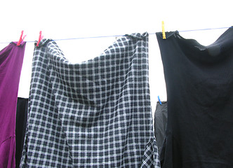 Image showing Clothesline  with some laundered clothes on white