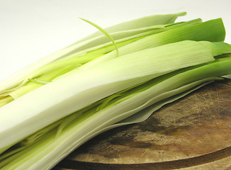 Image showing Green leek on a wooden plate in a  close-up view
