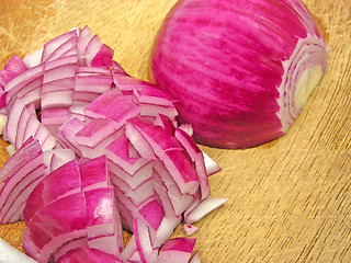 Image showing Diced red onion on a brown wooden plate