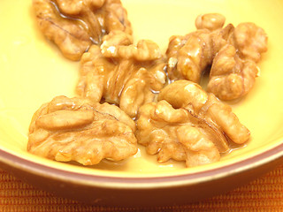 Image showing Walnut oil with walnuts in a bowl of ceramic in a close-up view