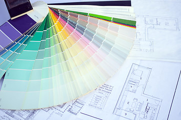 Image showing color palette samples lie on house design drawings 