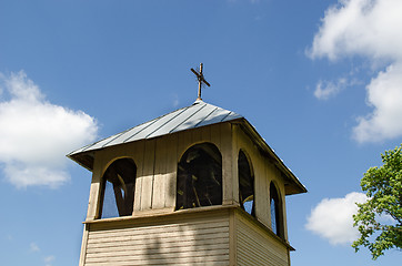 Image showing wooden village bell tower on blue sky background 