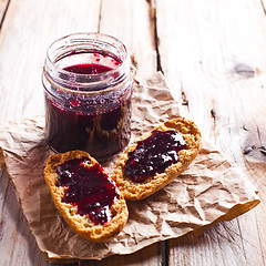 Image showing black currant jam in glass jar and crackers