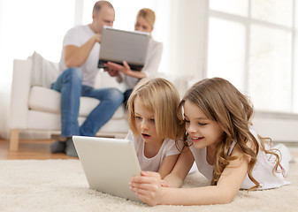 Image showing smiling sister with tablet pc and parents on back