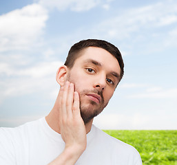 Image showing beautiful calm man touching his face