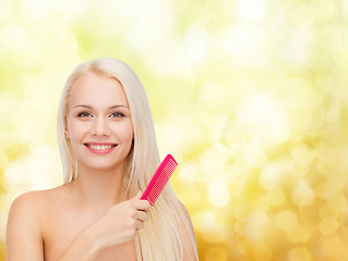 Image showing smiling woman with hair brush