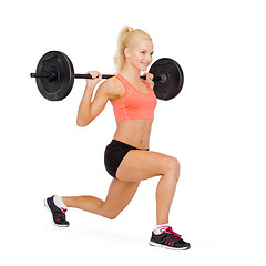 Image showing smiling sporty woman exercising with barbell