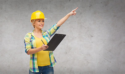 Image showing smiling woman in helmet with clipboard