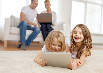Image showing smiling sister with tablet pc and parents on back