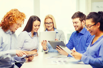 Image showing smiling team with table pc and papers working