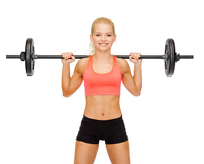 Image showing smiling sporty woman exercising with barbell