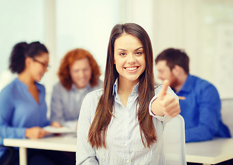 Image showing smiling young businesswoman showing thumbs up