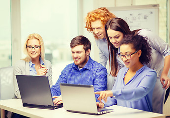 Image showing smiling team with laptop computers in office