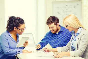 Image showing smiling team with table pc and papers working