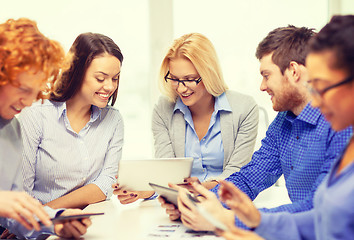 Image showing smiling team with table pc and papers working