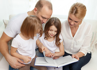 Image showing smiling family and two little girls with book