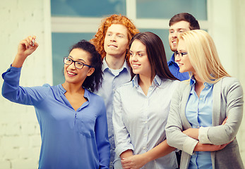 Image showing smiling creative team writing on virtual screen