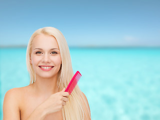 Image showing smiling woman with hair brush