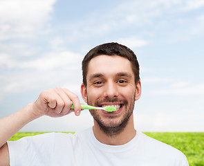 Image showing smiling young man with toothbrush