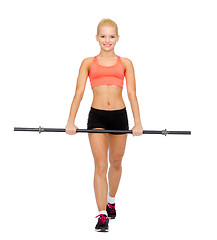 Image showing smiling sporty woman exercising with barbell