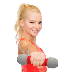 Image showing smiling beautiful sporty woman with dumbbell