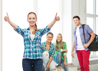 Image showing smiling girl in casual clothes showing thumbs up