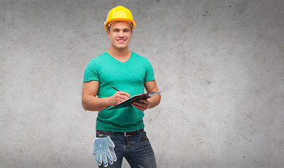 Image showing smiling man in helmet with clipboard