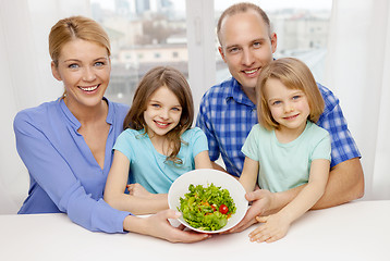 Image showing happy family with two kids with salad at home