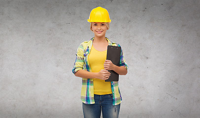 Image showing smiling woman in helmet with clipboard