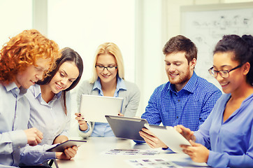 Image showing smiling team with table pc and papers working