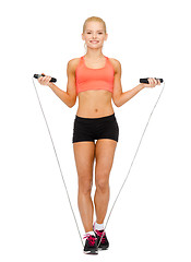 Image showing smiling sporty woman with with skipping rope