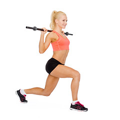 Image showing smiling sporty woman exercising with barbell