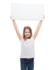 Image showing smiling little child holding blank white board