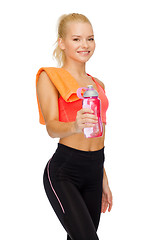 Image showing smiling sporty woman with water bottle and towel
