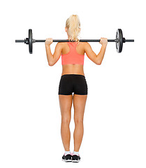 Image showing sporty woman exercising with barbell from the back