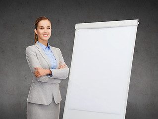 Image showing smiling businesswoman standing next to flipboard