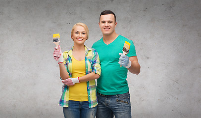 Image showing smiling couple with paintbrush