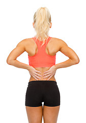 Image showing sporty woman touching her back