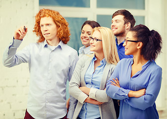 Image showing smiling creative team writing on virtual screen