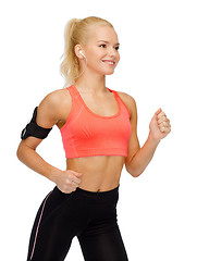 Image showing sporty woman running with smartphone and earphones