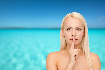 Image showing calm young woman with finger on lips