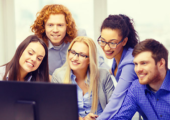 Image showing smiling business team looking at computer monitor