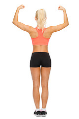 Image showing sporty woman from the back flexing her biceps