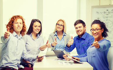 Image showing smiling team with table pc and papers working