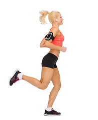 Image showing sporty woman running with smartphone and earphones