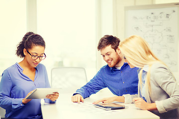 Image showing smiling team with table pc and papers working