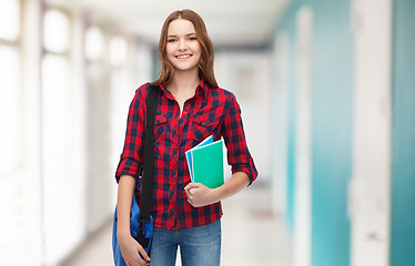 Image showing smiling female student with bag and notebooks